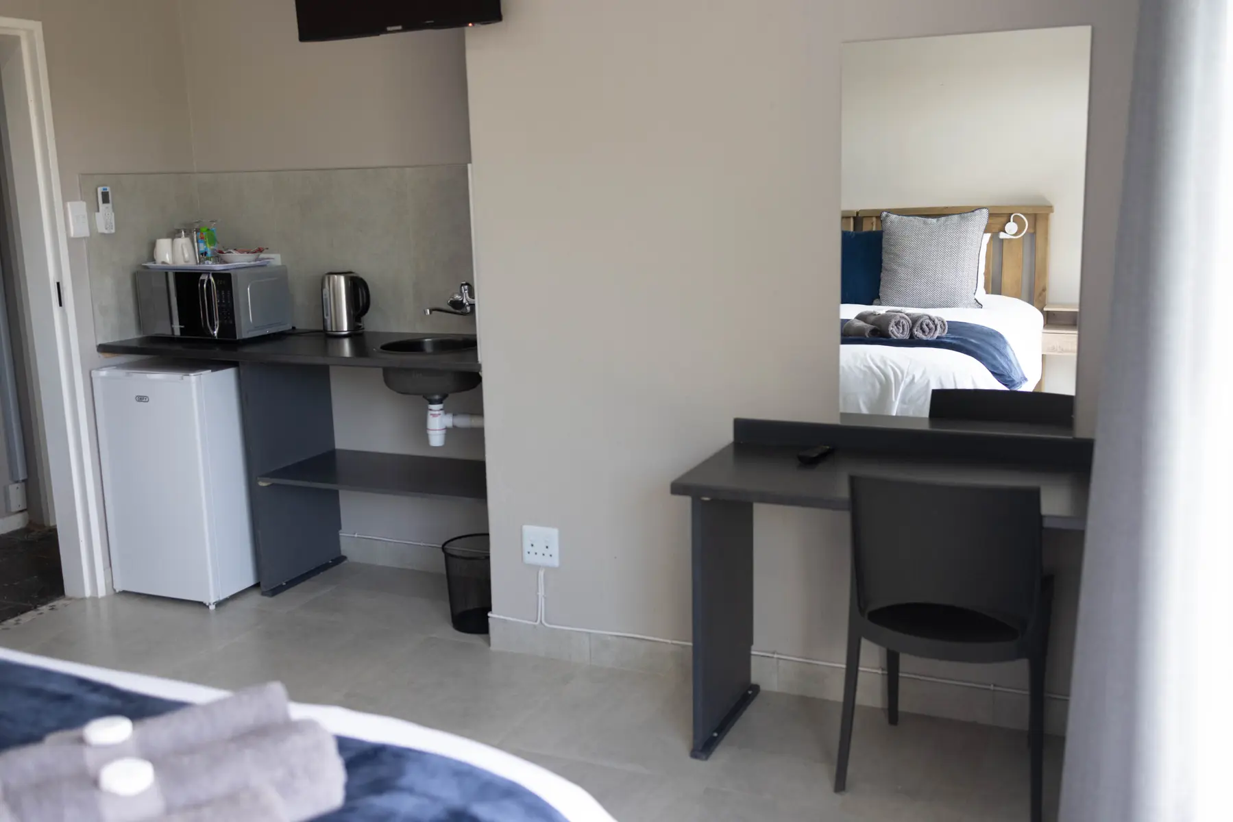A practical kitchenette and dressing area at Best Rest Guesthouse
