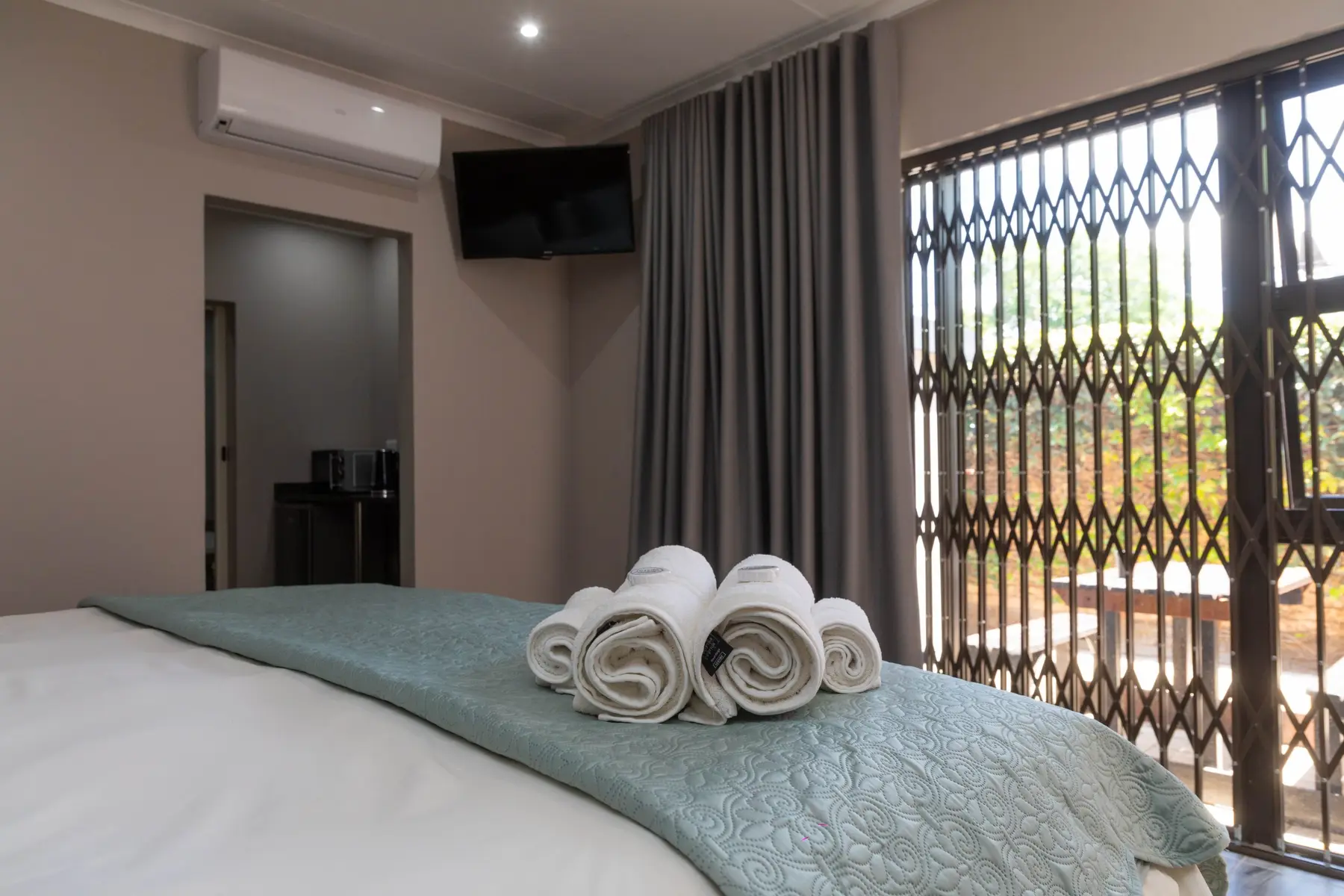 A light-filled bedroom with garden access at Opstal Guesthouse